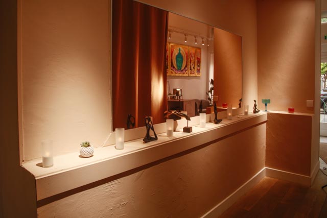 Salle de soin de l'institut Sawadee : bois sombre, tissus de soie et lumière tamisée.